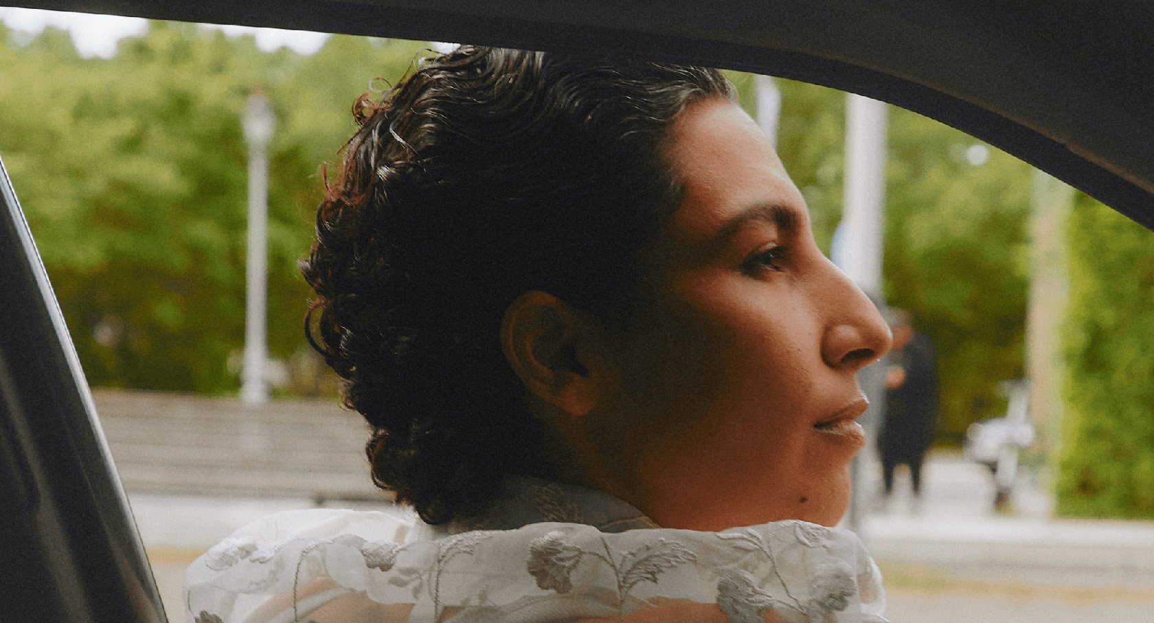 Individual looking out car window